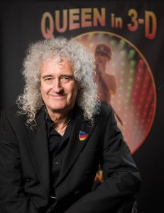 Brian May with Queen in 3-D in background